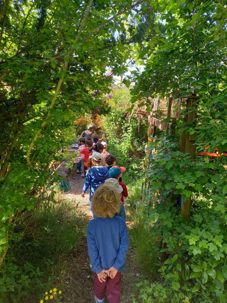 Bambini e bambine in fila indiana esplorano la cooperativa